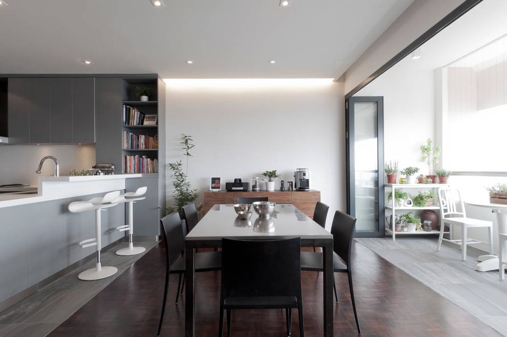 Idee per una sala da pranzo aperta verso la cucina design con pareti bianche e parquet scuro