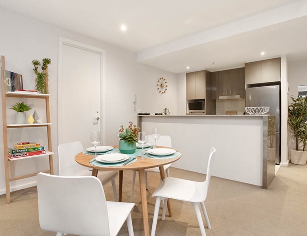 Immagine di una piccola sala da pranzo aperta verso il soggiorno contemporanea con pareti beige, moquette e pavimento marrone