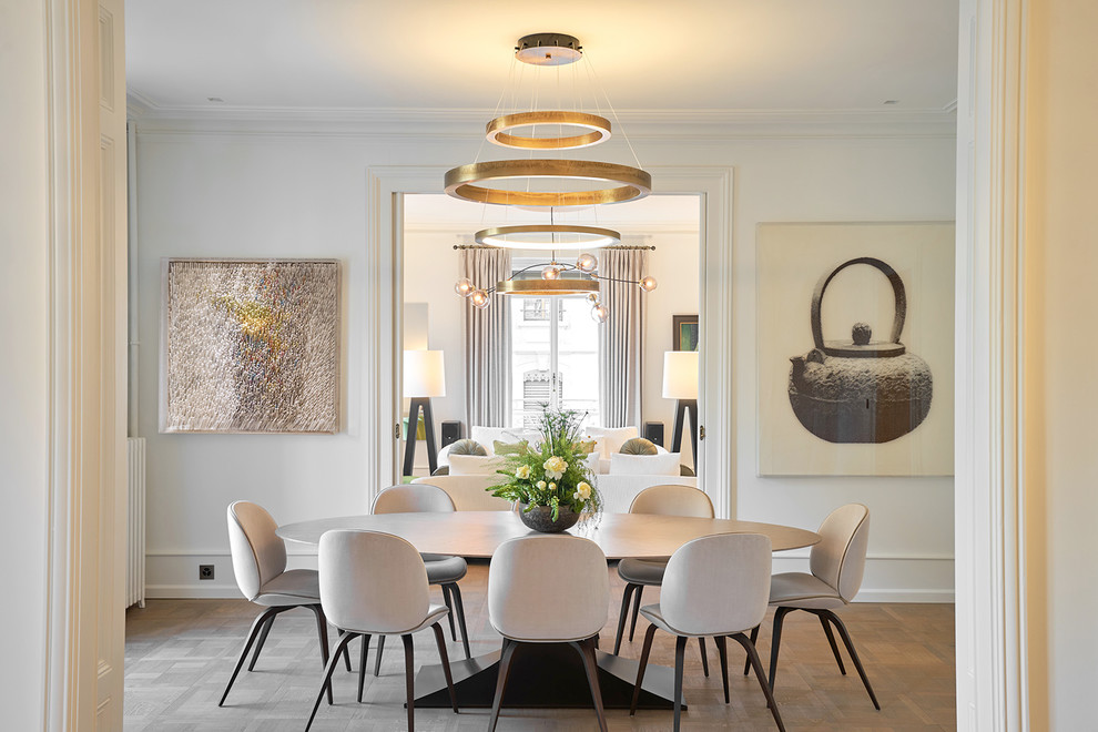 Cette image montre une grande salle à manger ouverte sur la cuisine minimaliste avec un mur blanc, un sol en bois brun et un sol beige.