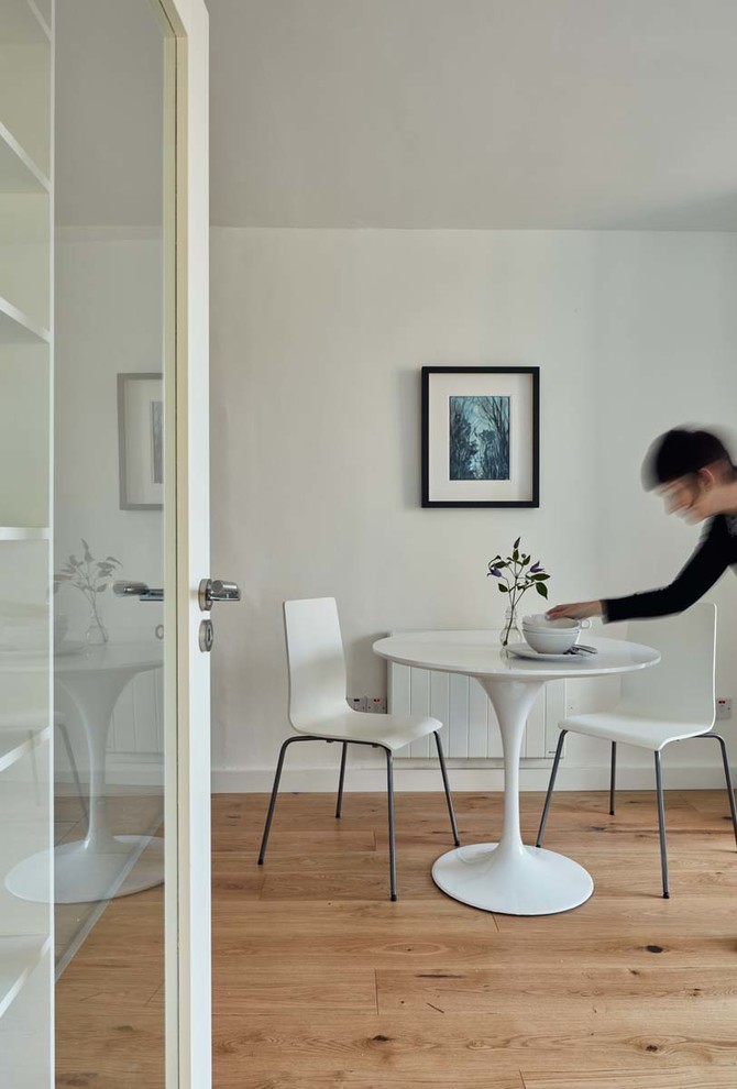Idee per una sala da pranzo aperta verso il soggiorno contemporanea con pareti bianche, pavimento in legno massello medio e nessun camino
