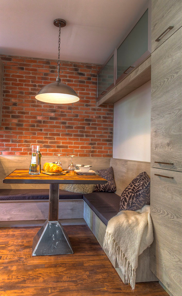 На фото: кухня-столовая среднего размера в стиле лофт с оранжевыми стенами, темным паркетным полом и коричневым полом с