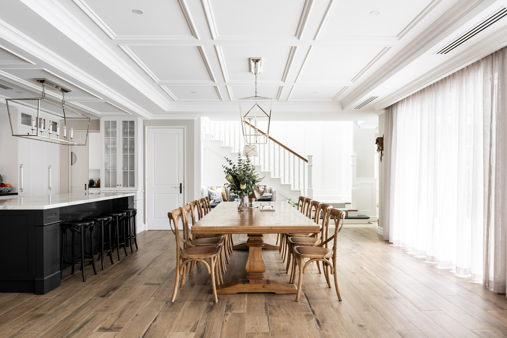 Inspiration pour une salle à manger ouverte sur la cuisine traditionnelle avec un mur beige, un sol en bois brun et un sol marron.