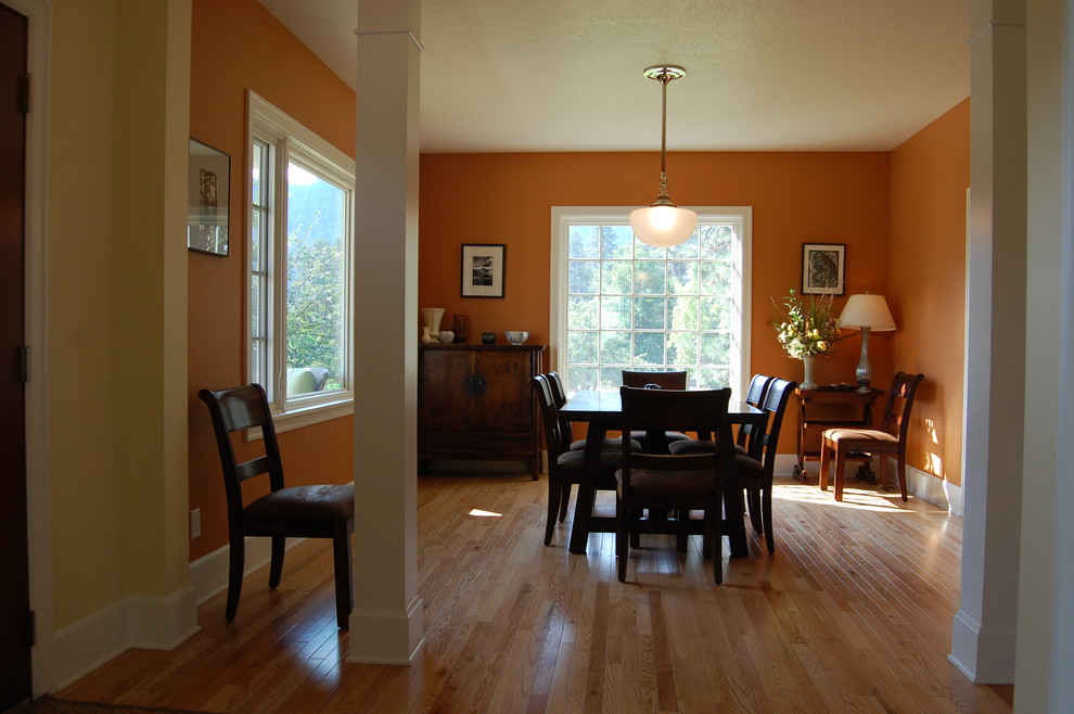 Ispirazione per una grande sala da pranzo tradizionale chiusa con pareti arancioni e parquet chiaro