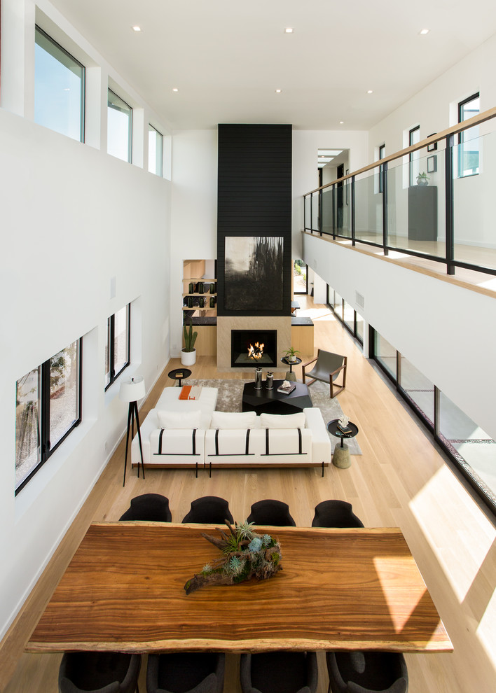 Example of a mid-sized trendy light wood floor and beige floor great room design in Los Angeles with white walls and no fireplace