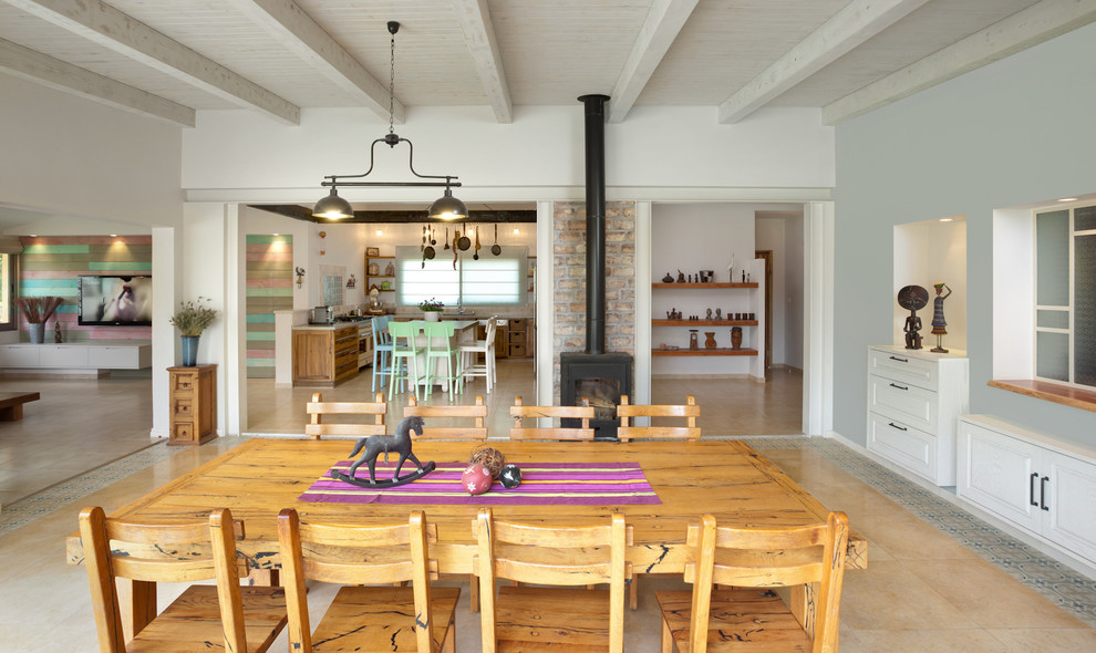 Idée de décoration pour une salle à manger design avec un mur gris et un poêle à bois.
