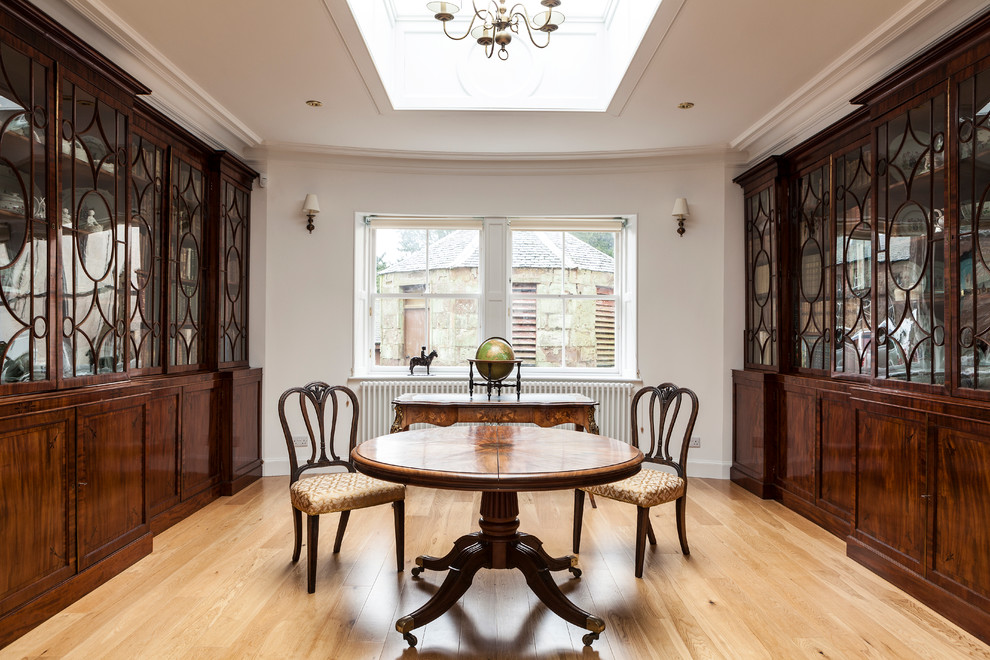 Immagine di una grande sala da pranzo classica chiusa con pareti bianche e parquet chiaro