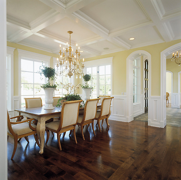 Imagen de comedor clásico grande abierto con paredes blancas y suelo de madera en tonos medios
