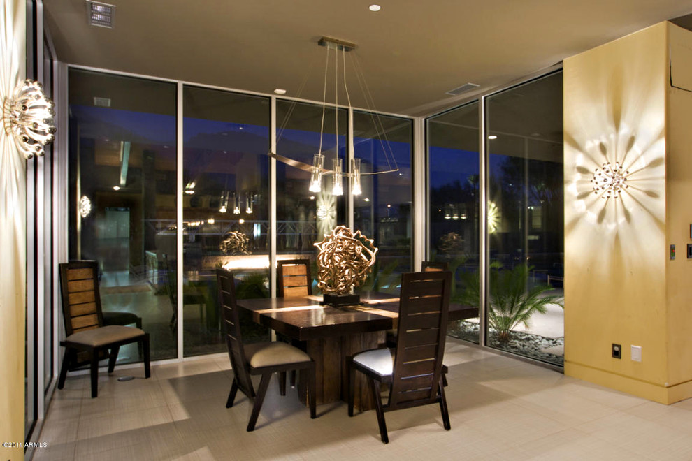 This is an example of a large modern enclosed dining room in Phoenix with yellow walls, porcelain flooring and no fireplace.