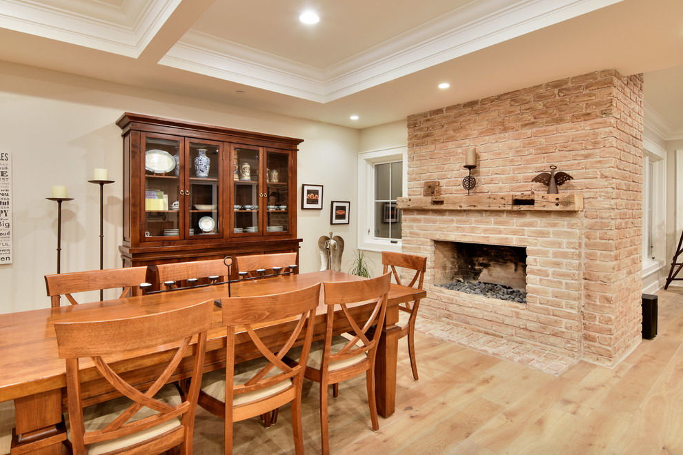 Aménagement d'une grande salle à manger ouverte sur le salon classique avec un mur beige, parquet clair, une cheminée standard, un manteau de cheminée en brique et un sol marron.