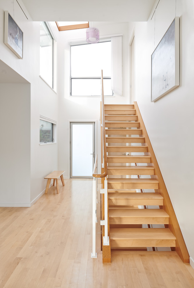 Идея дизайна: большая деревянная лестница на больцах в стиле модернизм с деревянными ступенями и стеклянными перилами