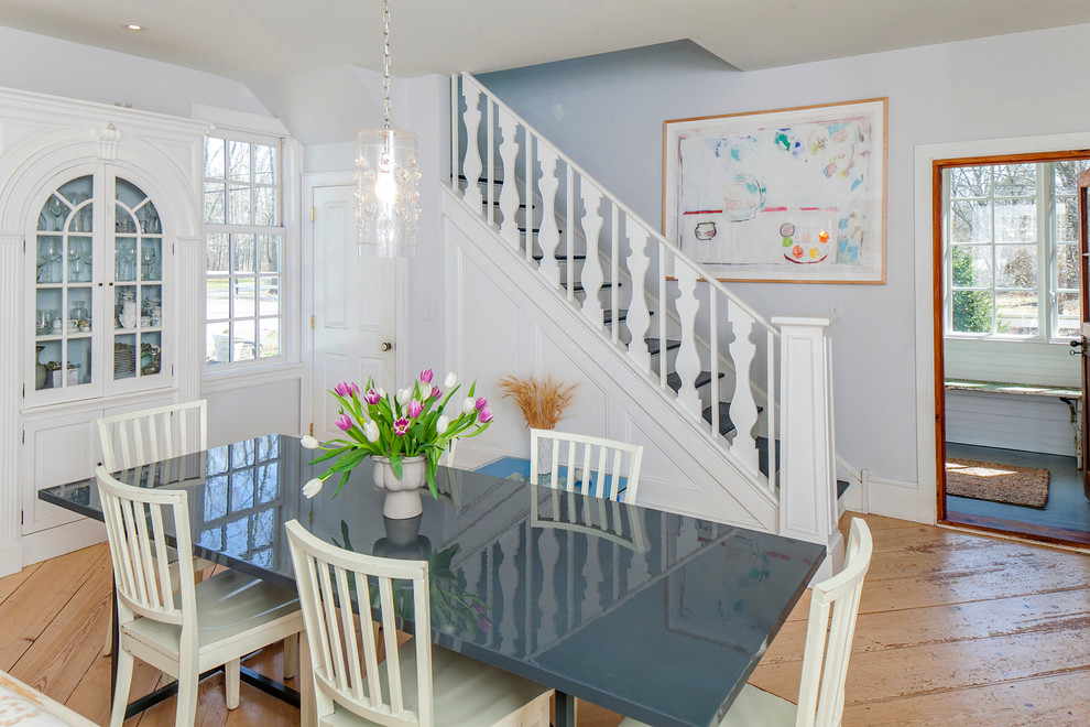 Mid-sized transitional medium tone wood floor dining room photo in New York with white walls