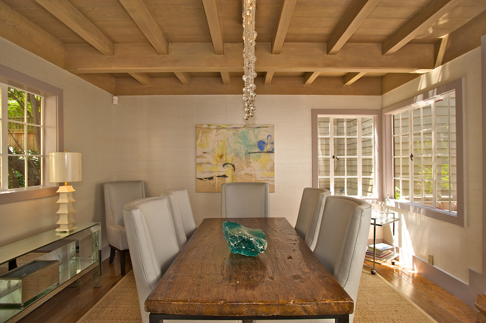 Cette photo montre une salle à manger tendance avec un mur beige, un sol en bois brun et éclairage.