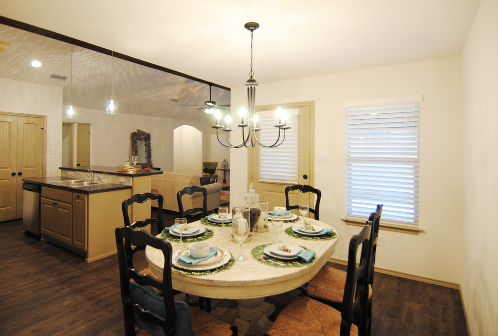 Cette image montre une salle à manger ouverte sur la cuisine bohème de taille moyenne avec un mur blanc et un sol en vinyl.