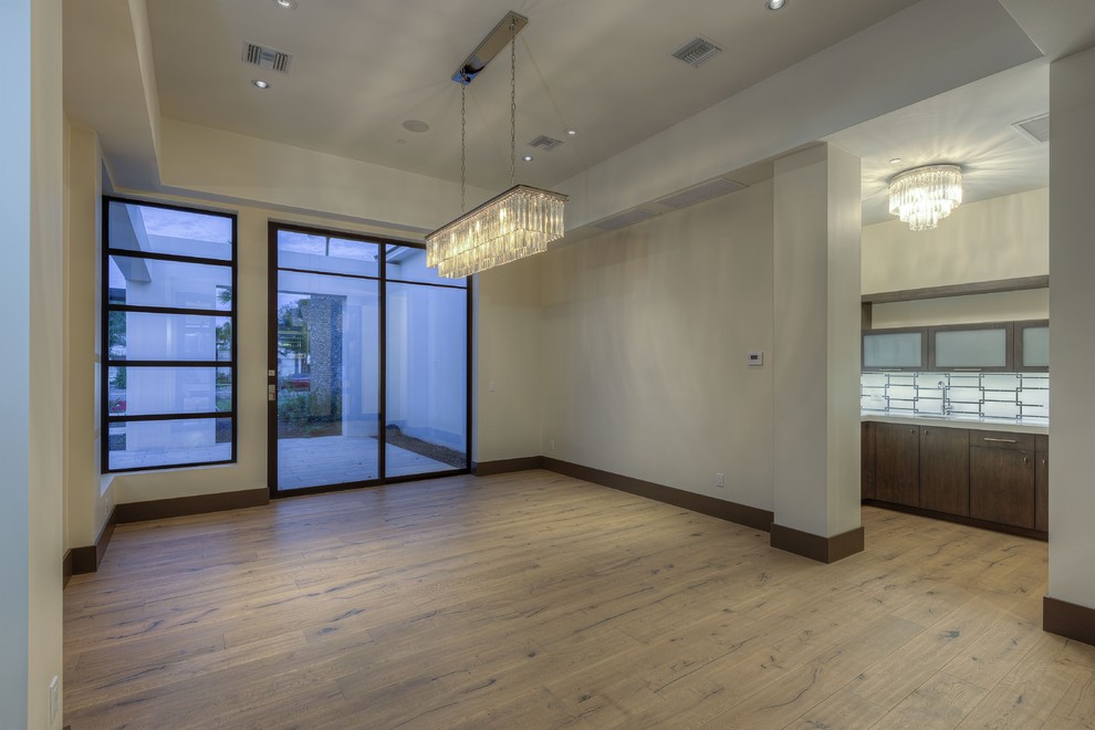 Geschlossenes, Großes Modernes Esszimmer ohne Kamin mit weißer Wandfarbe, hellem Holzboden und gefliester Kaminumrandung in Phoenix