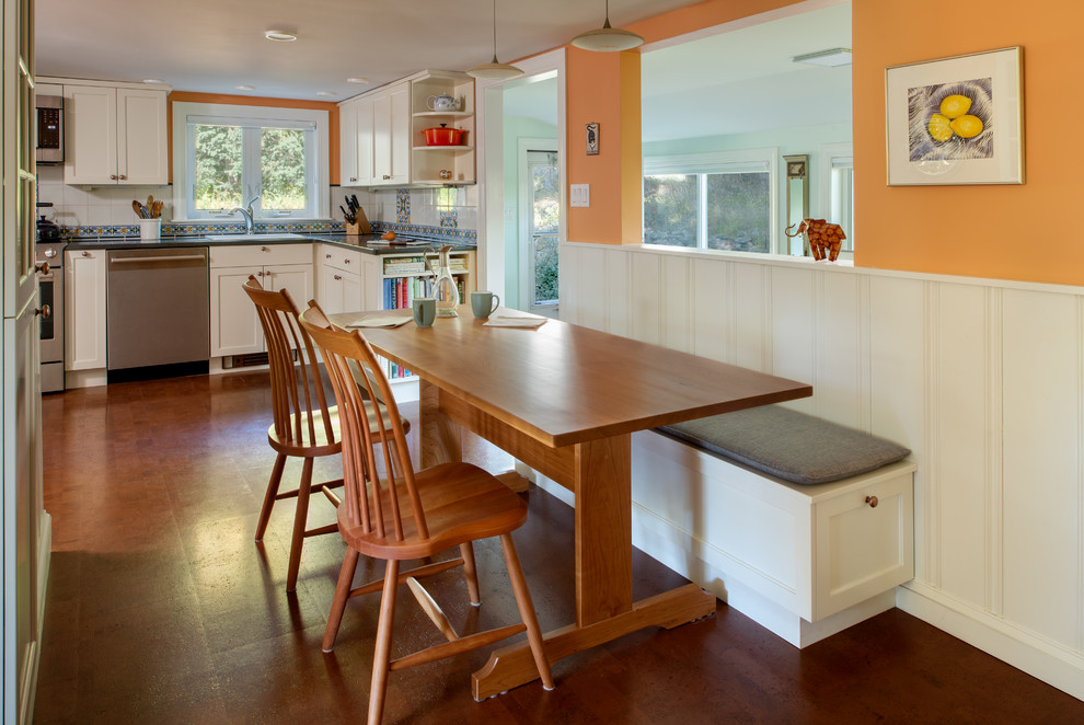 Cette image montre une salle à manger traditionnelle avec un mur orange, un sol en liège et un sol marron.