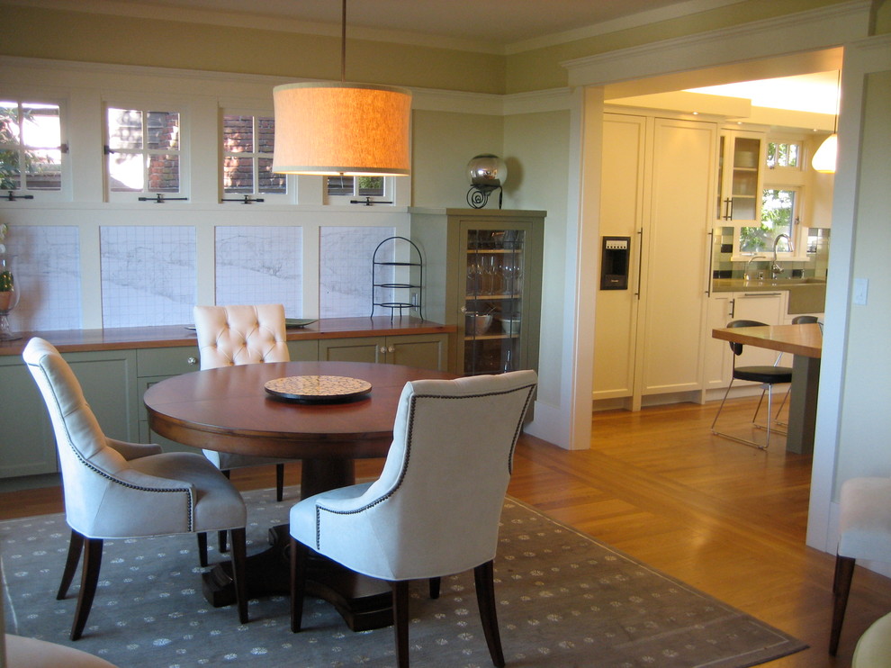 Idée de décoration pour une salle à manger ouverte sur la cuisine minimaliste de taille moyenne avec un sol en bois brun.