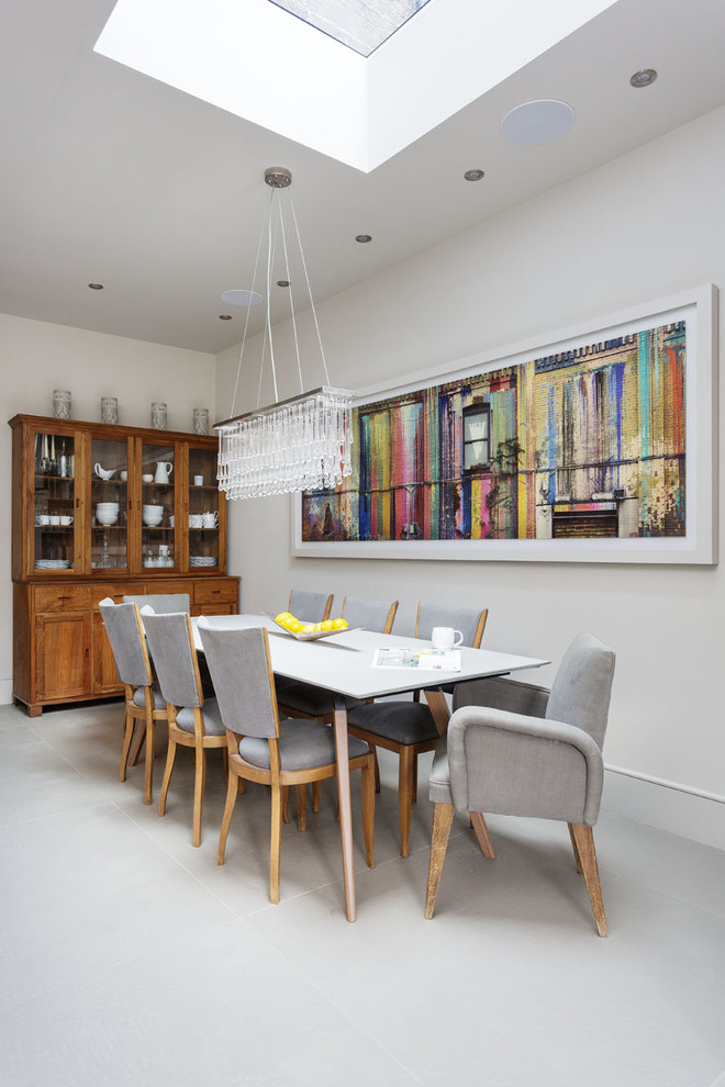 Immagine di una grande sala da pranzo aperta verso la cucina tradizionale con pareti bianche e pavimento bianco