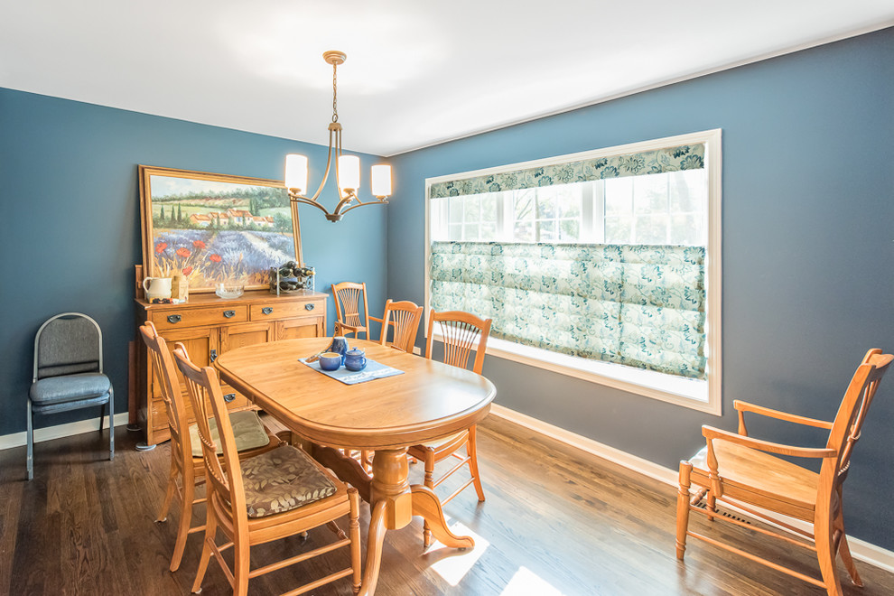 Réalisation d'une salle à manger ouverte sur le salon tradition de taille moyenne avec un mur bleu, un sol en bois brun, aucune cheminée et un sol bleu.