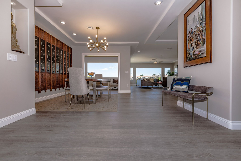 Immagine di una grande sala da pranzo aperta verso il soggiorno etnica con pavimento in vinile, pavimento grigio, pareti grigie e nessun camino