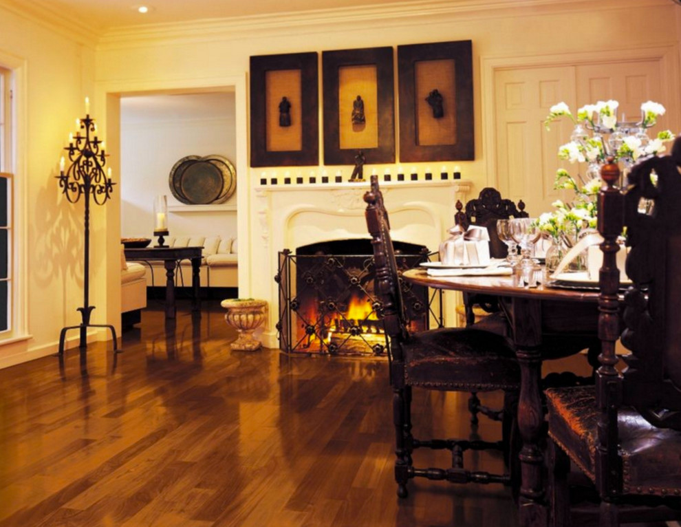 Réalisation d'une salle à manger tradition fermée et de taille moyenne avec un mur blanc, un sol en bois brun, une cheminée standard, un manteau de cheminée en plâtre et un sol marron.