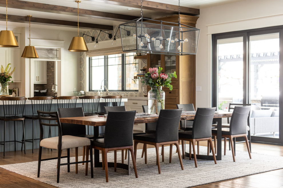 Foto di una sala da pranzo aperta verso la cucina classica con pareti bianche, pavimento in legno massello medio e nessun camino