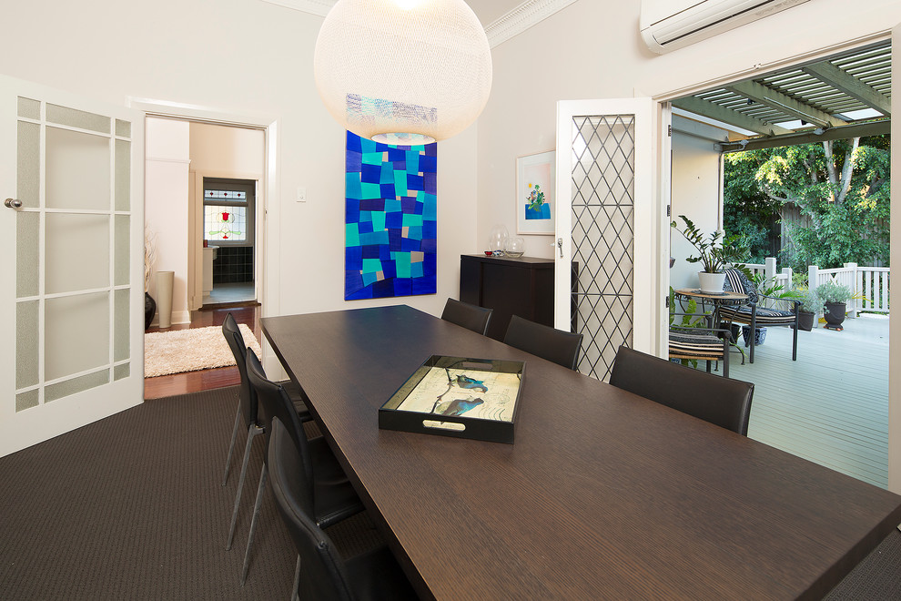 Photo of a medium sized bohemian enclosed dining room in Brisbane with beige walls and carpet.