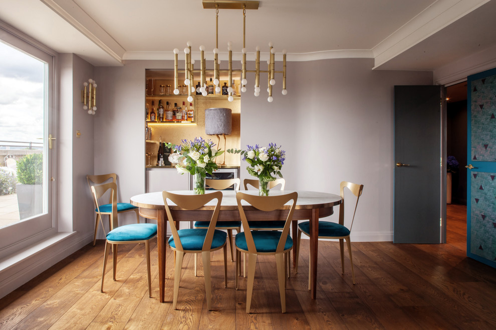 Photo of a medium sized contemporary dining room in London with medium hardwood flooring, brown floors and purple walls.