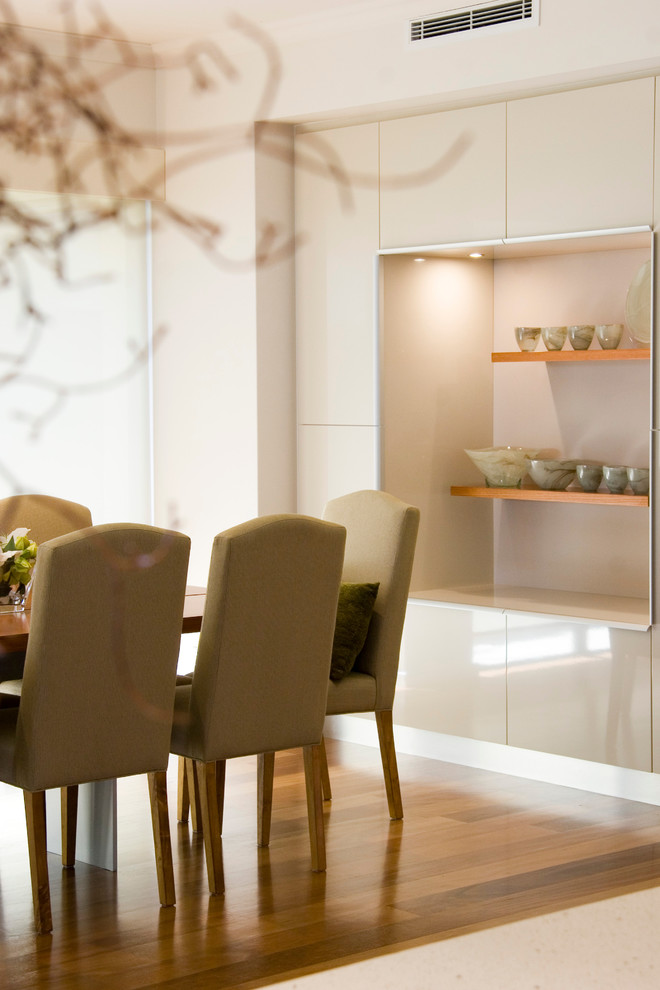 Immagine di una grande sala da pranzo aperta verso il soggiorno minimalista con pareti bianche, parquet chiaro e pavimento giallo