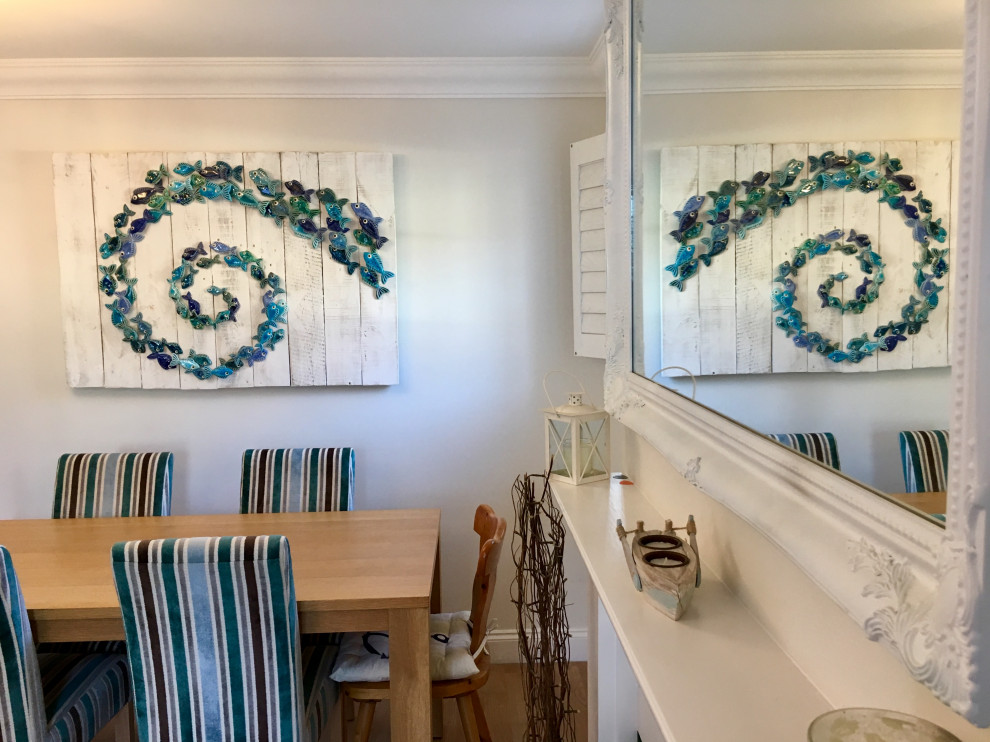 Inspiration for a small beach style dining room in Channel Islands with white walls.
