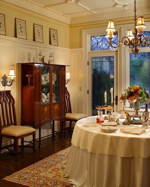 Photo of a large traditional dining room in Other with yellow walls and dark hardwood flooring.