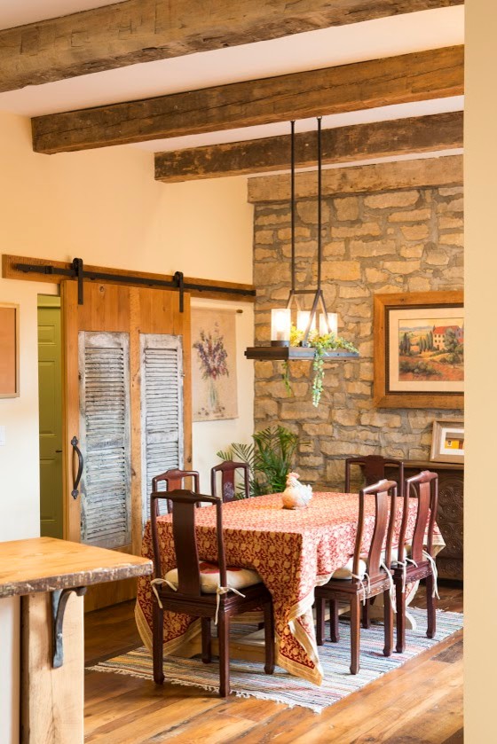 Esempio di una sala da pranzo aperta verso la cucina american style di medie dimensioni con pareti beige, pavimento in legno massello medio e nessun camino