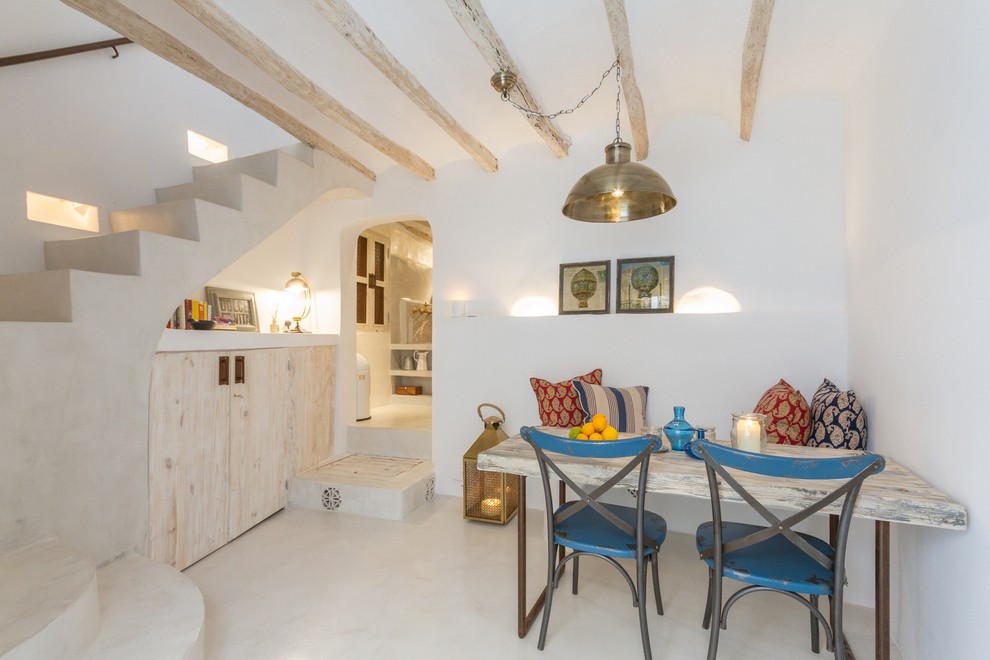 На фото: маленькая гостиная-столовая в средиземноморском стиле с белыми стенами для на участке и в саду с