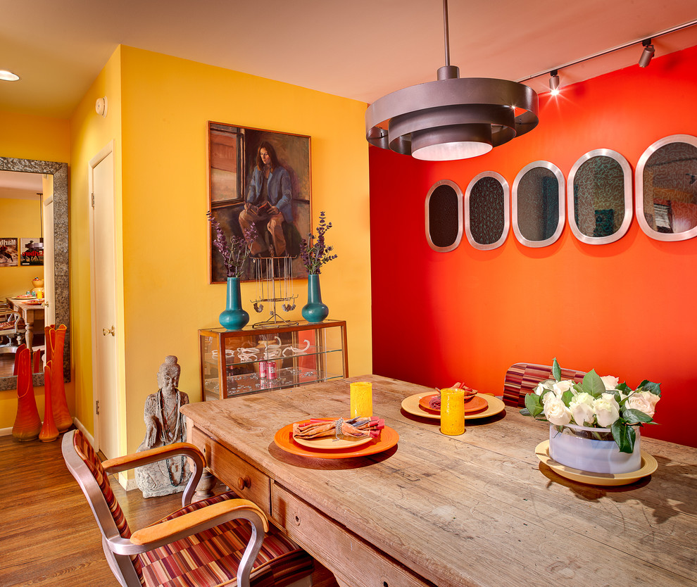 Imagen de comedor bohemio pequeño sin chimenea con suelo de madera en tonos medios y paredes multicolor