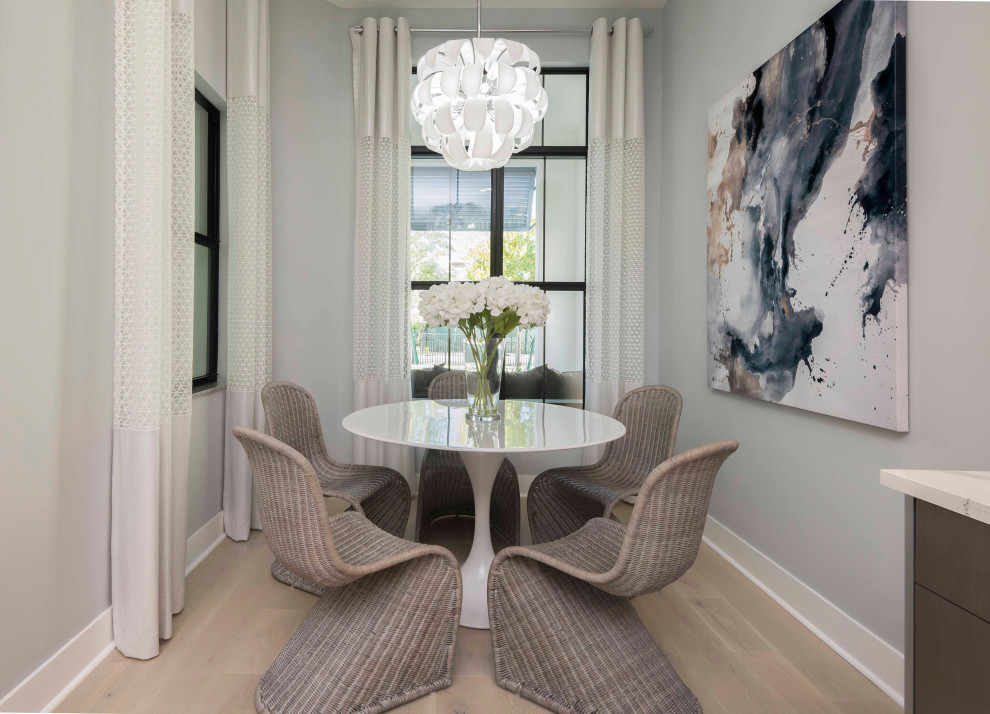 Photo of a coastal dining room in Miami with banquette seating and white walls.