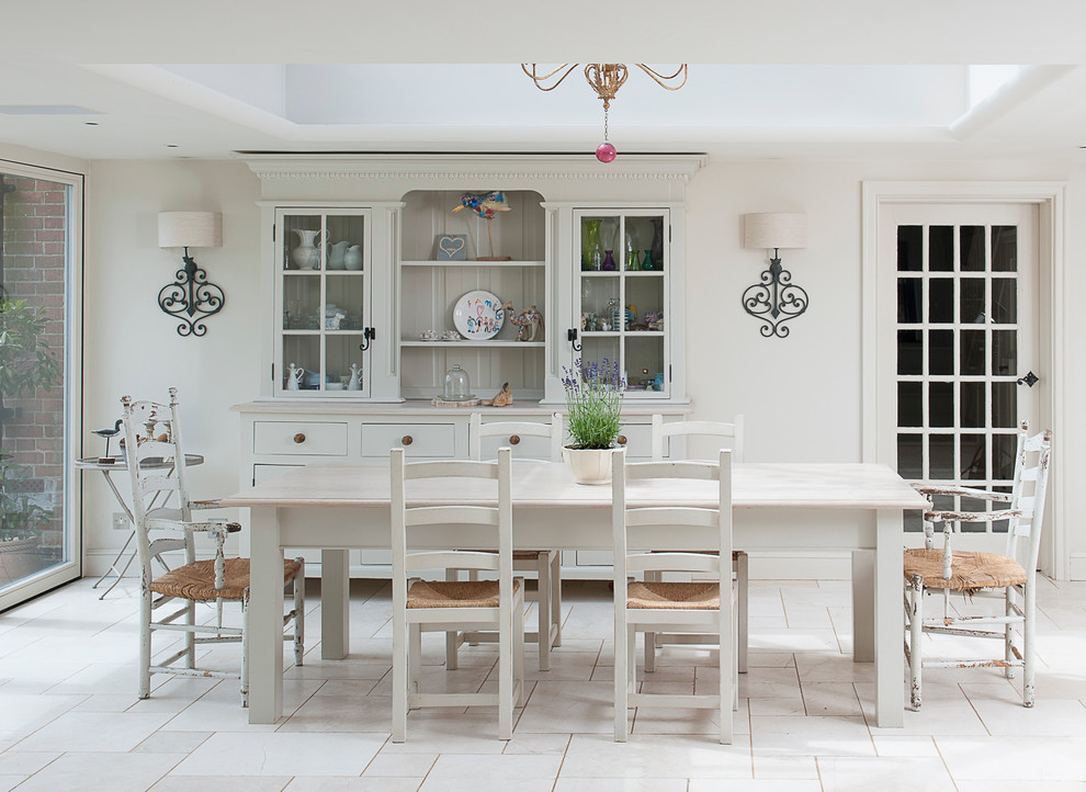 Foto di una grande sala da pranzo aperta verso la cucina classica con nessun camino, pareti bianche, pavimento in pietra calcarea e pavimento bianco