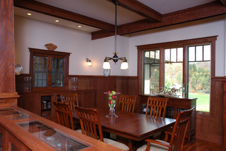 Inspiration pour une salle à manger craftsman de taille moyenne avec un mur blanc et un sol en bois brun.