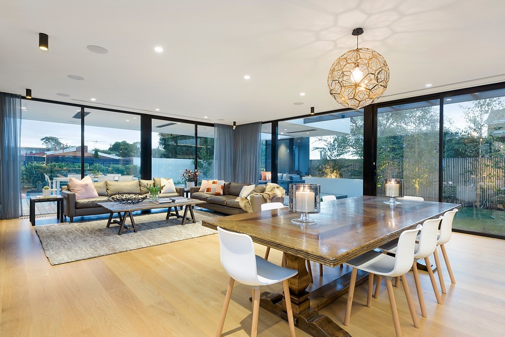 Photo of a large contemporary open plan dining room in Melbourne with white walls, medium hardwood flooring and brown floors.