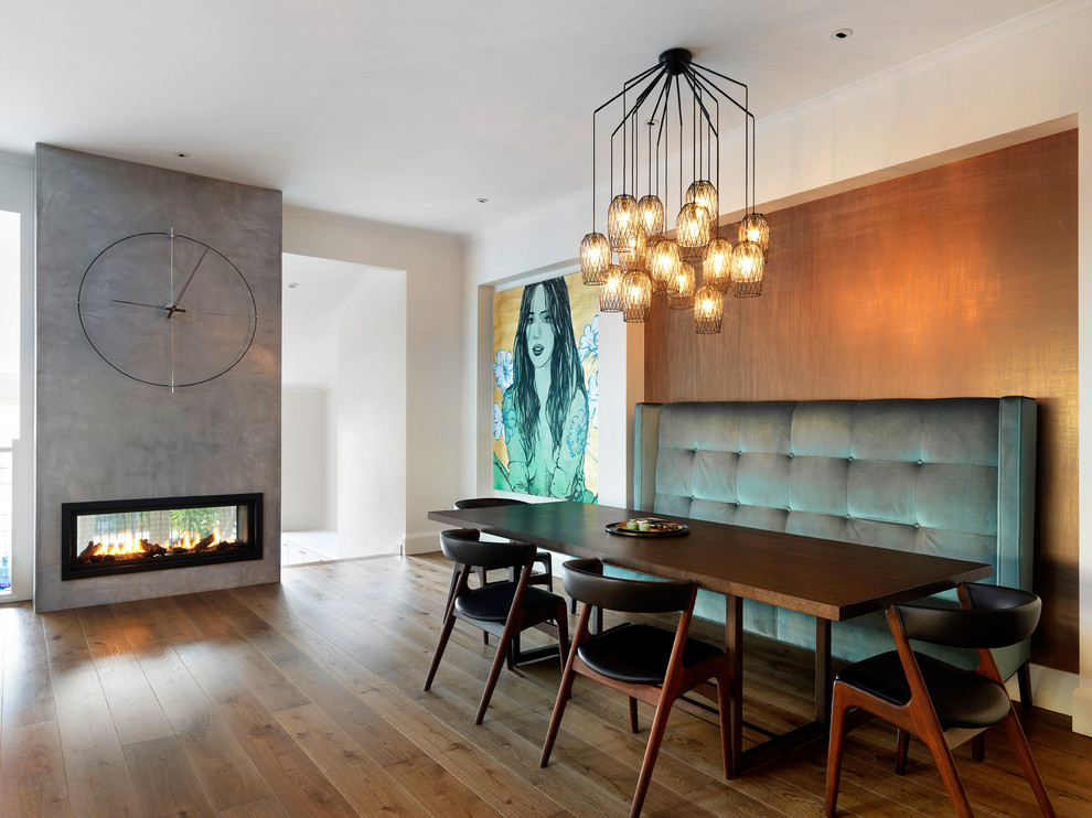 Idée de décoration pour une grande salle à manger design avec un mur blanc, un sol en bois brun, une cheminée ribbon, un manteau de cheminée en béton et un sol marron.