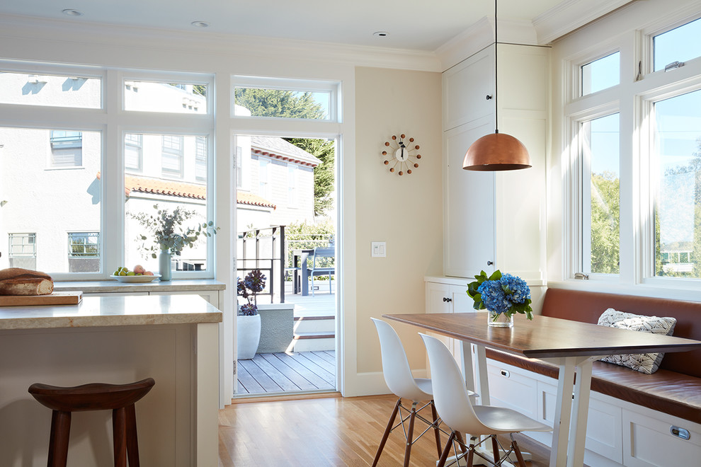 Inspiration pour une salle à manger ouverte sur la cuisine traditionnelle avec un mur blanc, un sol en bois brun et un sol orange.