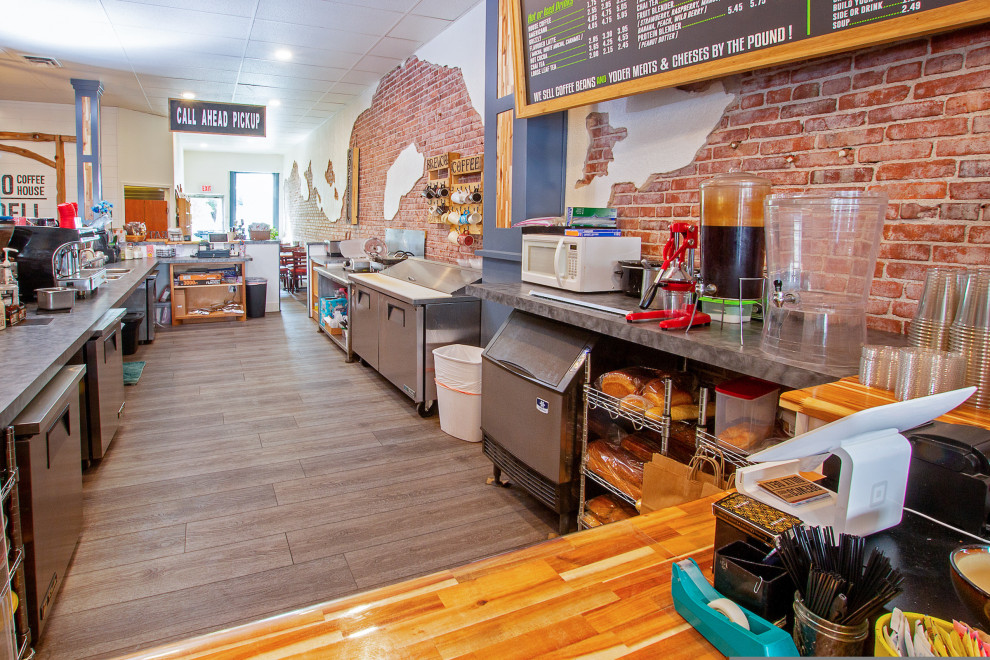 Foto di un'ampia sala da pranzo aperta verso la cucina industriale con pareti multicolore, pavimento in vinile e pavimento grigio