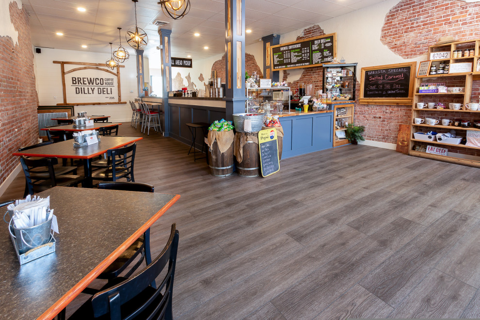 Foto di un'ampia sala da pranzo aperta verso la cucina industriale con pareti multicolore, pavimento in vinile e pavimento grigio