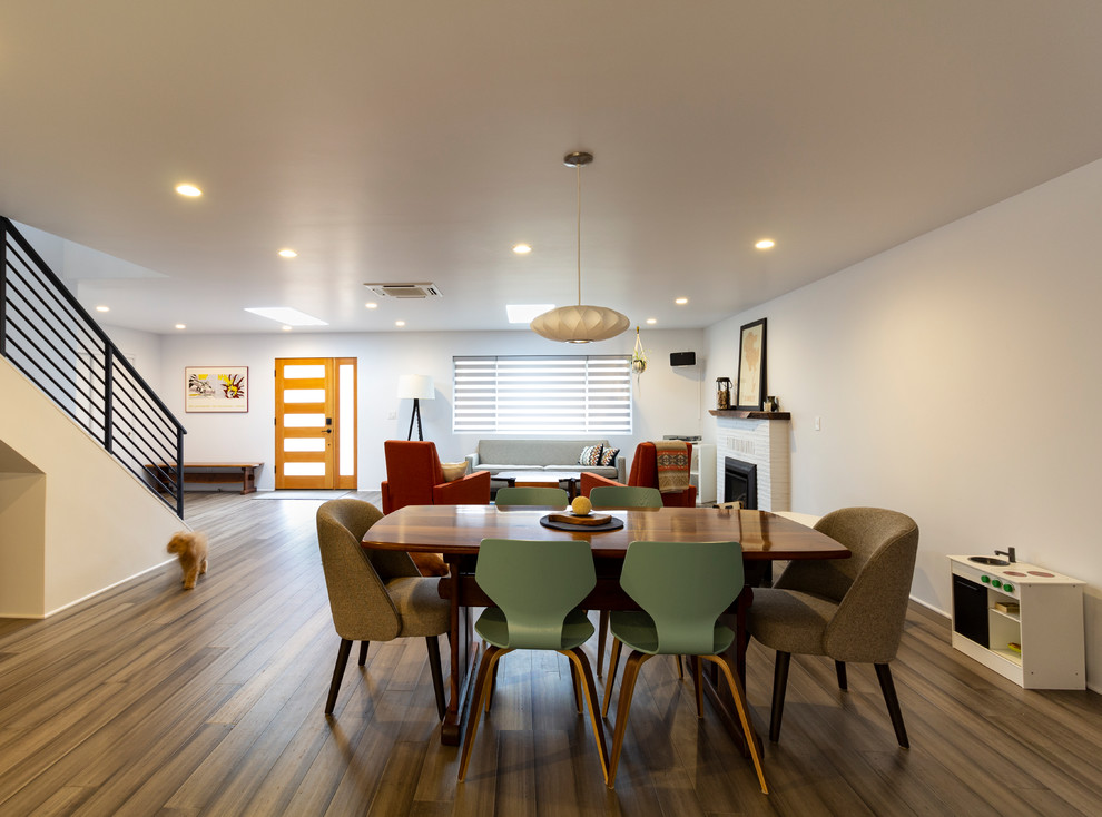 Medium sized contemporary open plan dining room in Other with white walls, medium hardwood flooring, brown floors and feature lighting.