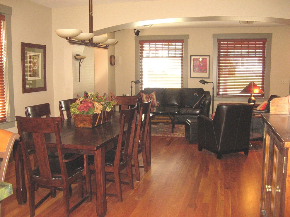 Aménagement d'une petite salle à manger ouverte sur le salon craftsman avec un mur beige et un sol en bois brun.