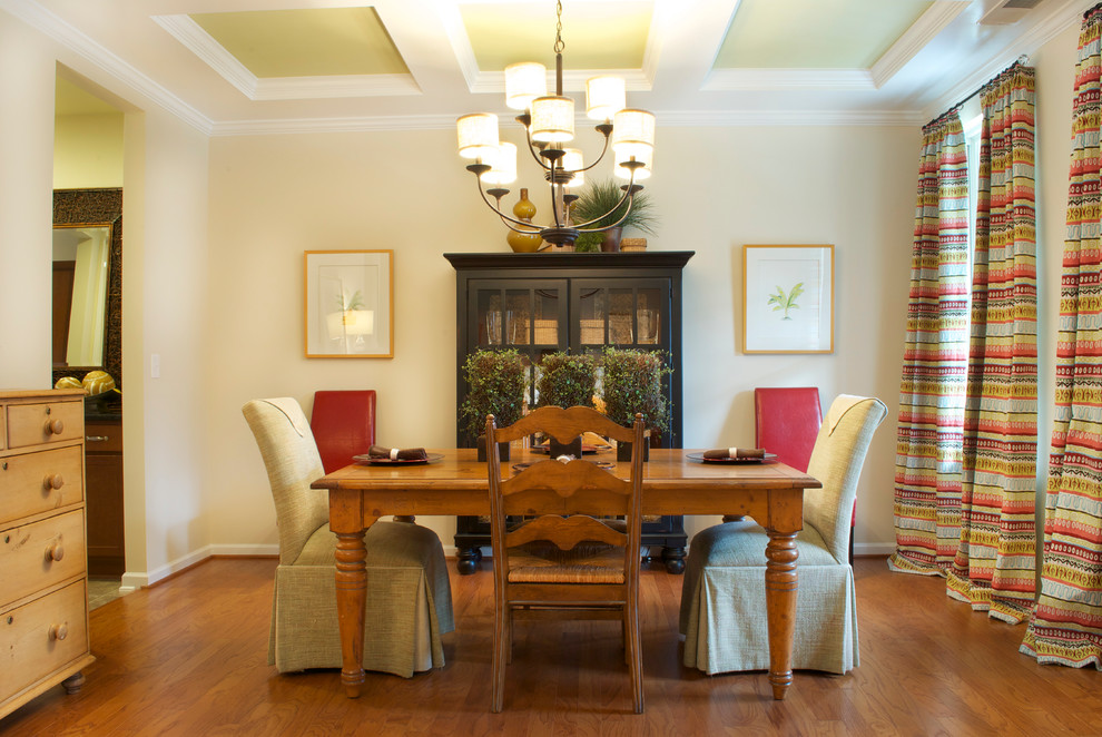 Modelo de comedor clásico con paredes beige, suelo de madera en tonos medios y cortinas