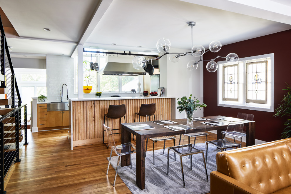 Foto di una sala da pranzo aperta verso il soggiorno contemporanea di medie dimensioni con pavimento in legno massello medio, pareti rosse e pavimento marrone