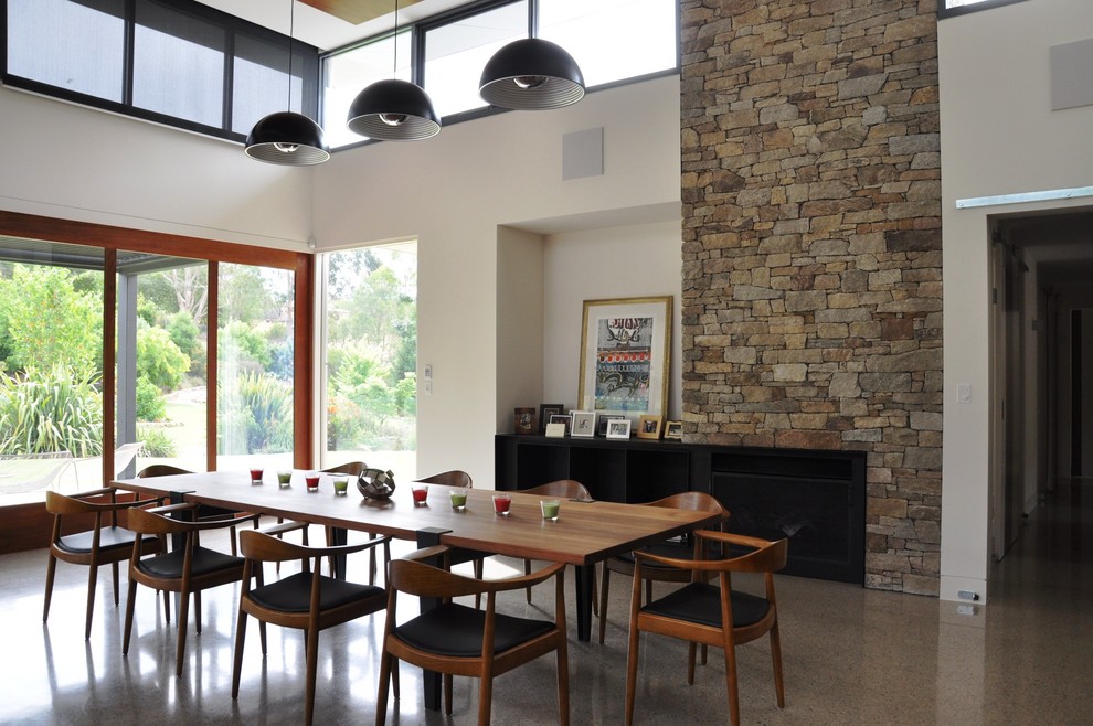 Réalisation d'une grande salle à manger ouverte sur la cuisine design avec un mur beige et sol en béton ciré.