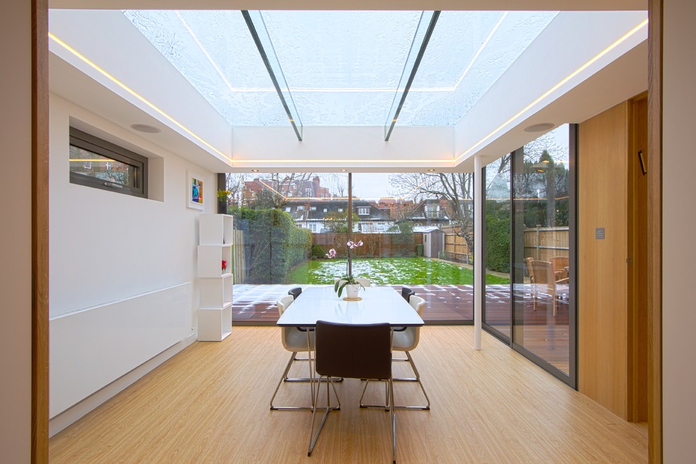 Modernes Esszimmer mit weißer Wandfarbe und hellem Holzboden in London