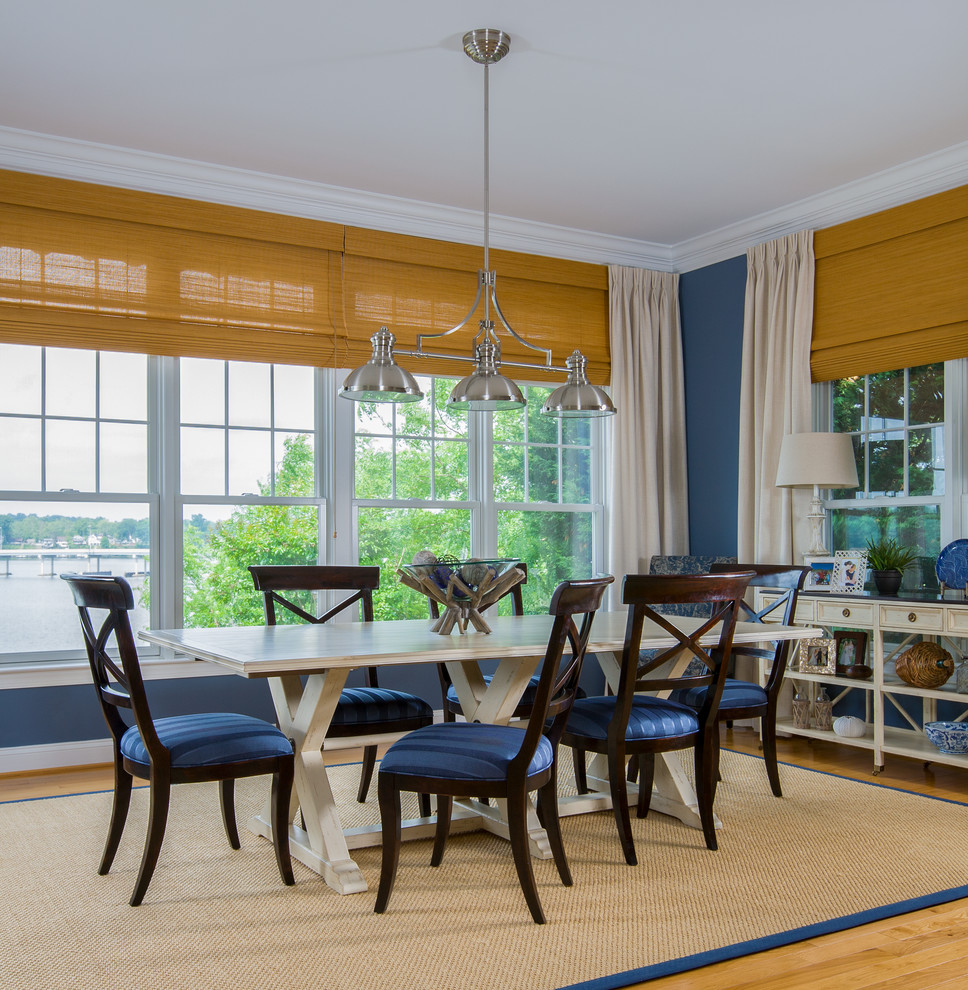 Foto di una sala da pranzo aperta verso il soggiorno chic di medie dimensioni con pareti blu, parquet chiaro, nessun camino e pavimento marrone