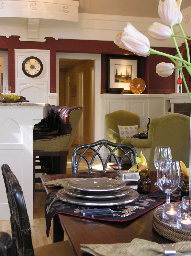Réalisation d'une salle à manger ouverte sur le salon tradition avec un mur rouge et un sol en bois brun.