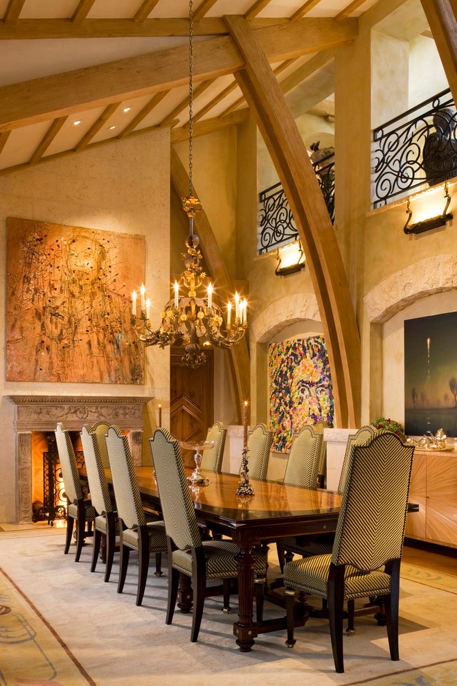 Geschlossenes, Mittelgroßes Mediterranes Esszimmer mit beiger Wandfarbe, Kamin, braunem Holzboden und Kaminumrandung aus Stein in Denver